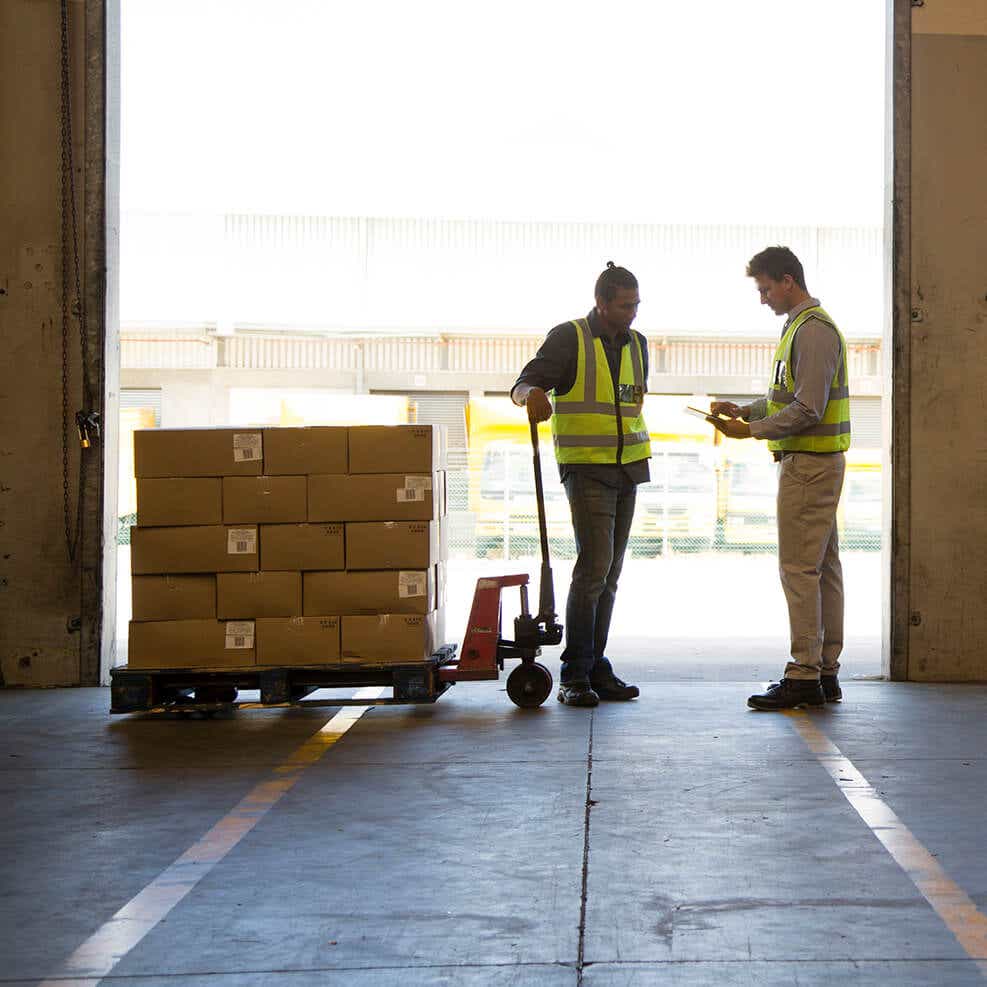 two men in warehouse doorway discussing CPG demands