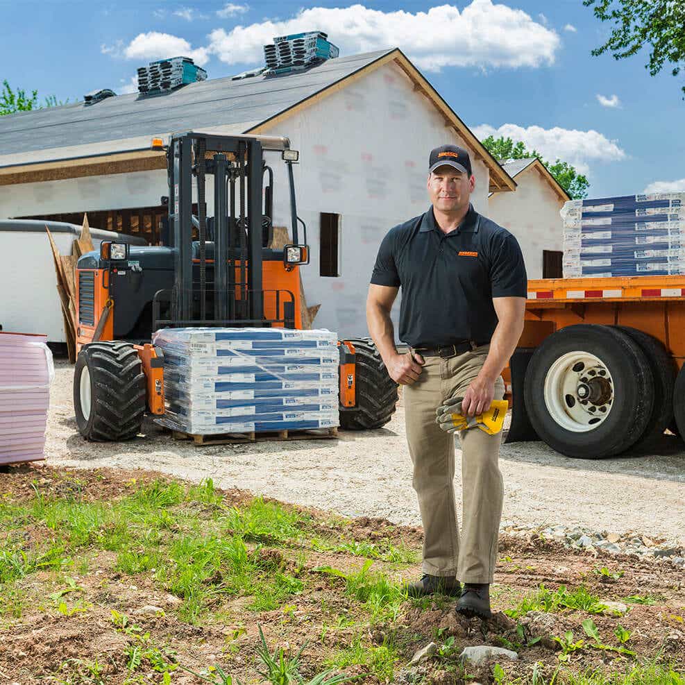 man in front of construction site and construction materials