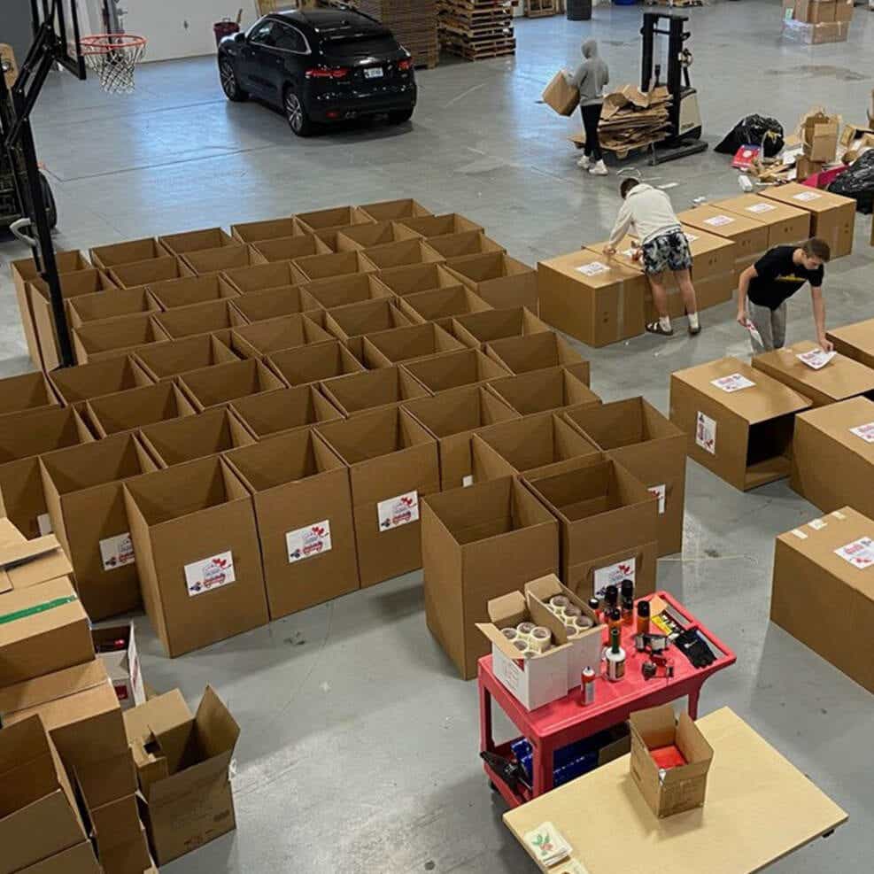 A warehouse associate unloading a charity delivery made by a Schneider driver at no-cost