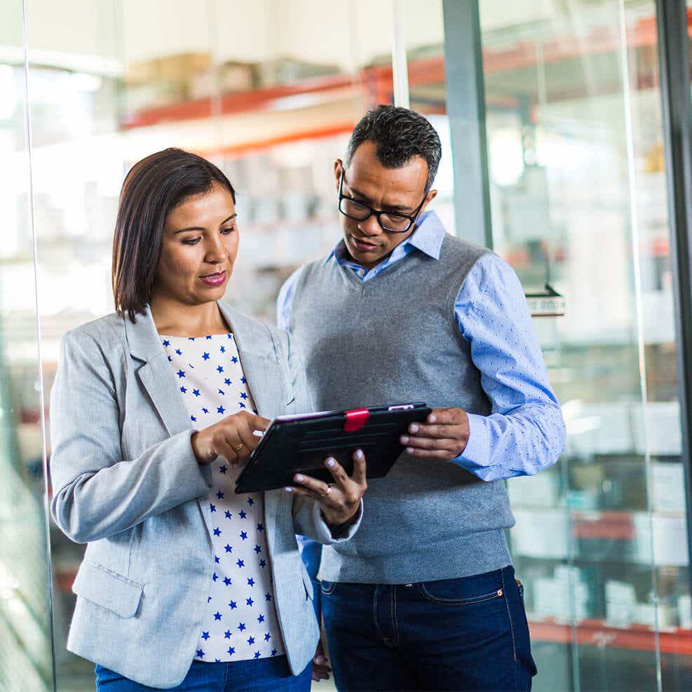 woman and man talking while looking at a device