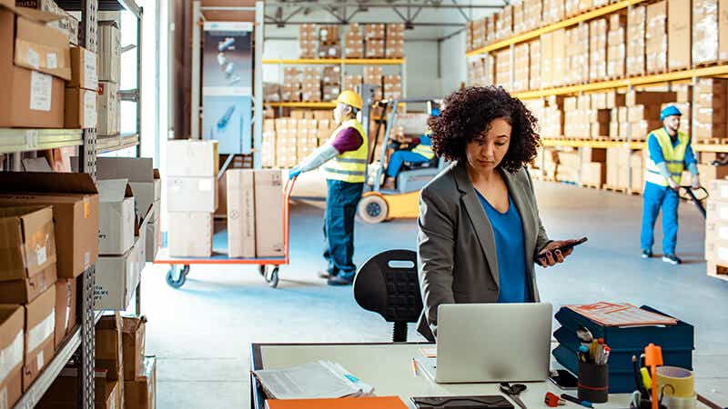 An LTL shipping expert using a computer in a warehouse.